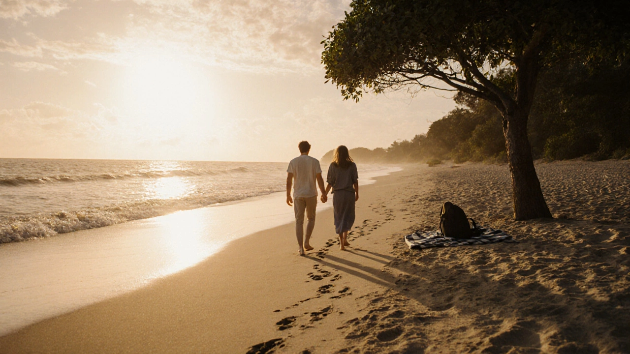 A married pair walks barefoot on a beach at sunset, hand in hand, with no distractions in sight.