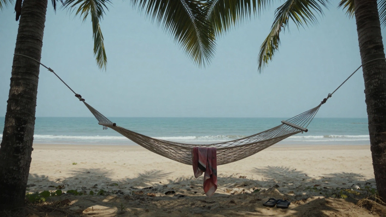 An empty hammock and flip-flops beside palm trees on a pristine beach, ocean stretching to the horizon.