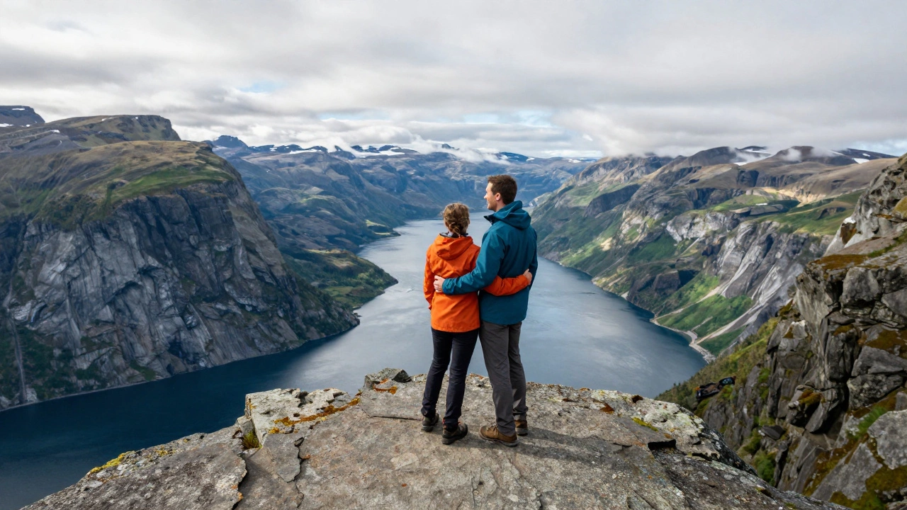 Adventurous couple embracing on a cliff overlooking dramatic mountainous scenery
