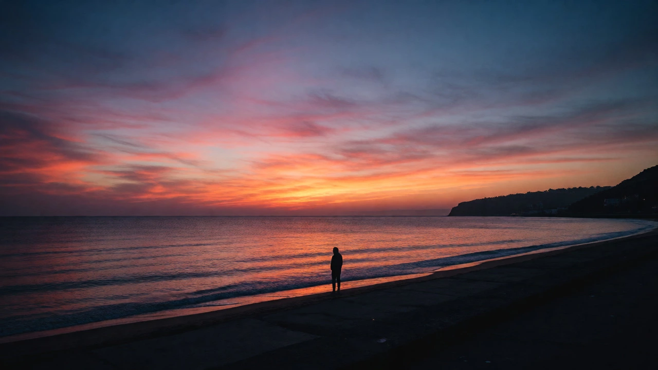 Silhouette of a person watching sunset at a quiet beach